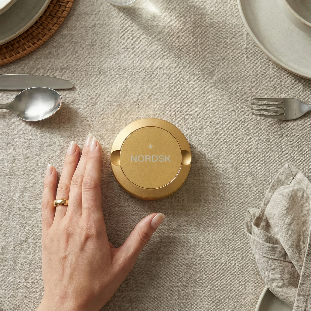Women at dinner with a gold snus tin from NORDSK