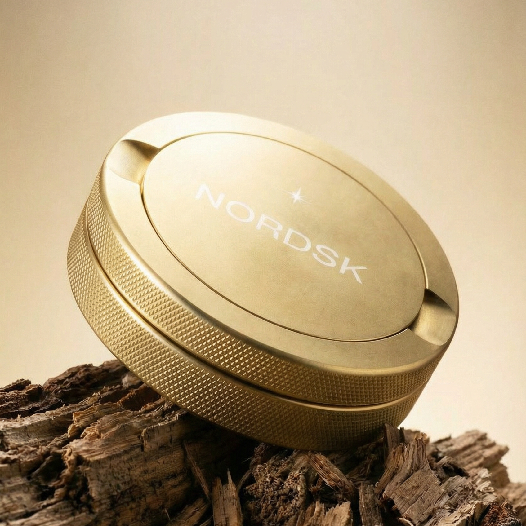 Gold metal snus tin on wooden log and studio background.