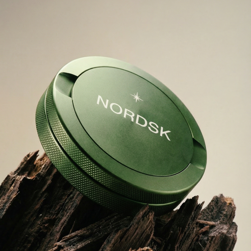 NORDSK Olive Green metal snus tin product shot on wooden log. Designed in Sweden